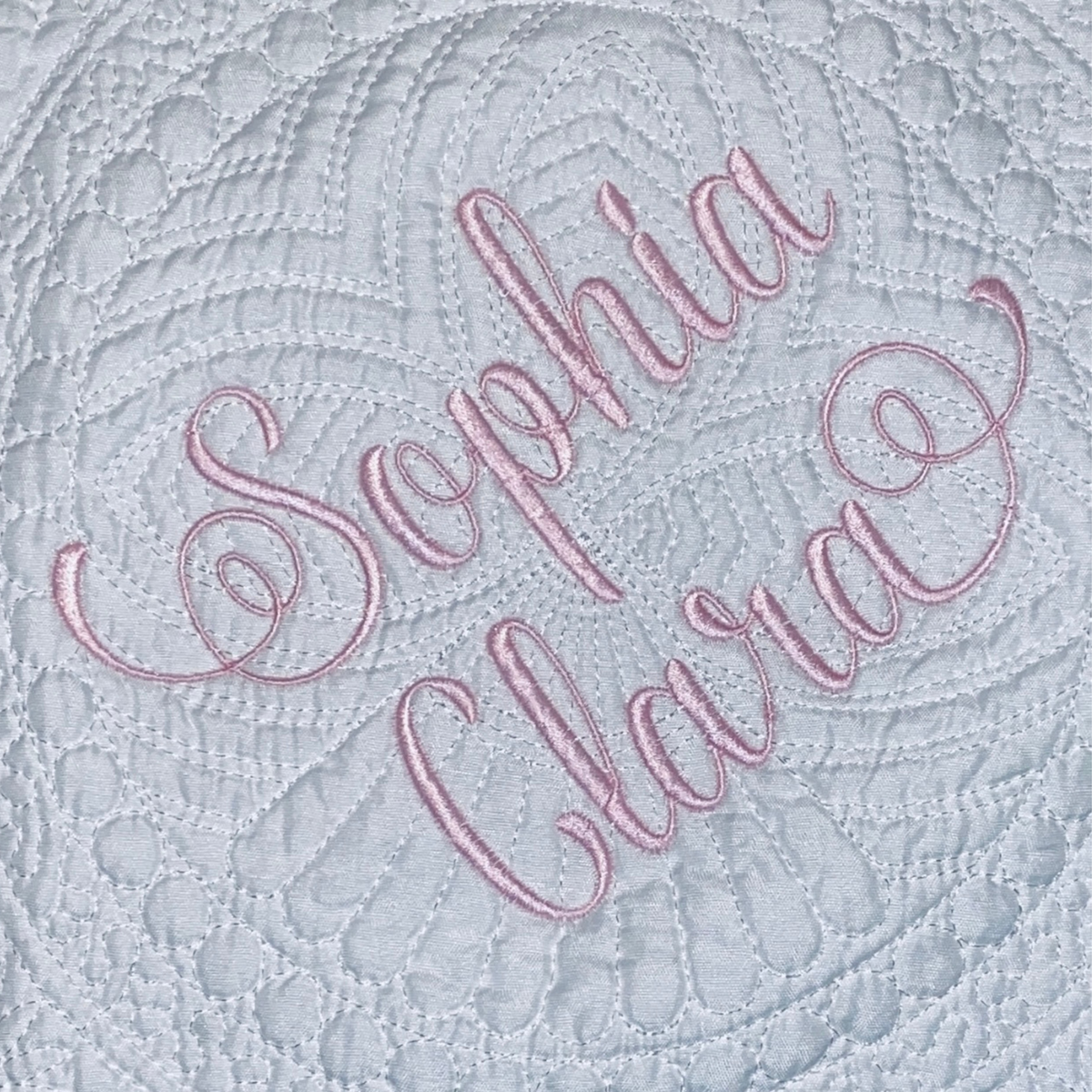zoomed 2-name font on white baby quilt